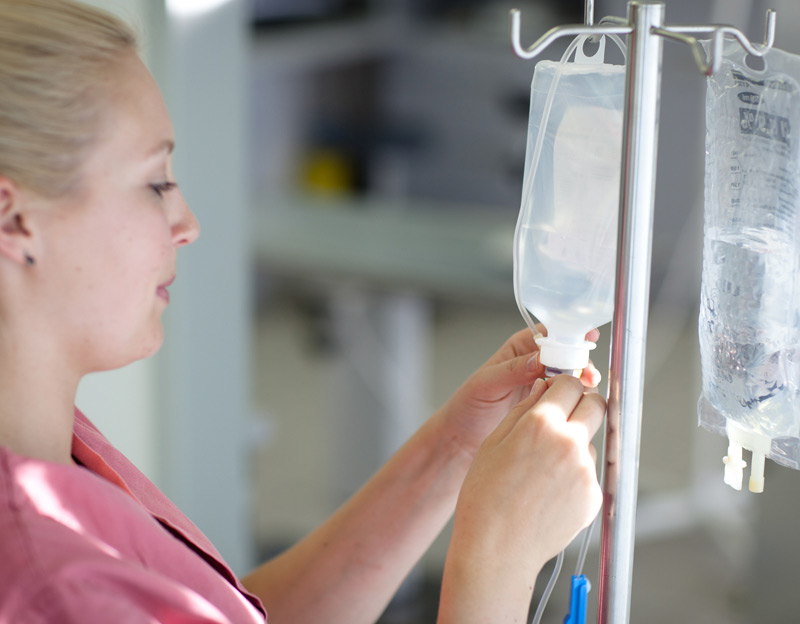 Female-nurse-preparing-IV-infusion